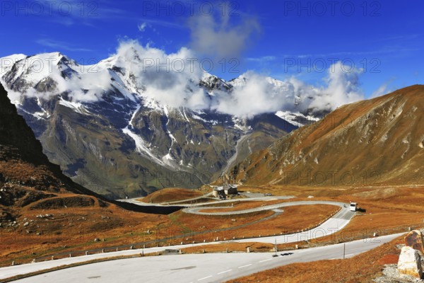 Famous picturesque views of the road in Austrian Alps - Grossglocknershtrasse. Ideal highway winds high in the mountains. The highest mountain peaks covered with fresh snow