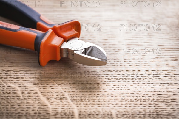 Nippers close up on wooden board construction concept