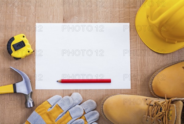 Pencil paper helmet boots gloves hammer tapeline on wooden board organized copyspace