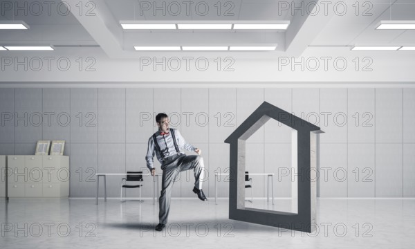 Determined businessman going to break with kick house concrete figure