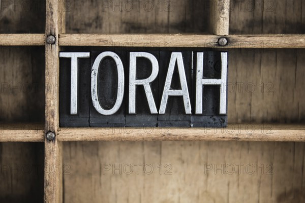 The word TORAH written in vintage metal letterpress type in a wooden drawer with dividers