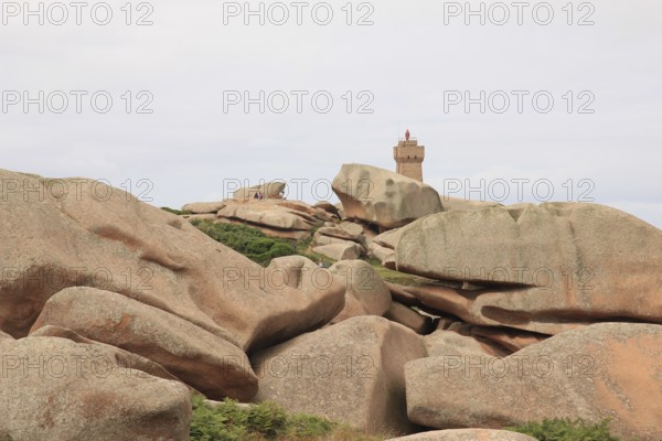 Granite boulder and lighthouse in Brittany, France