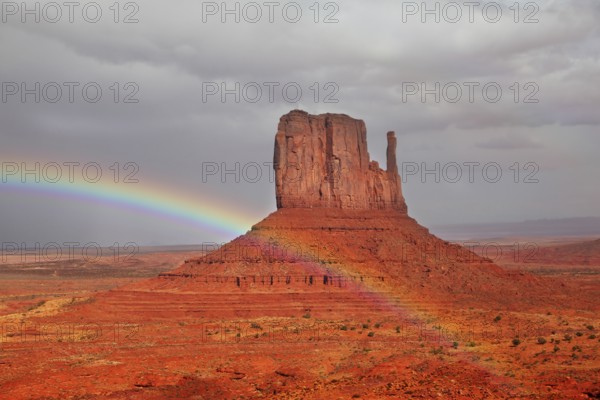 Red Desert. Monument Valley - Navajo Reservation during the summer thunderstorms. The magnificent rainbow over the famous red sandstone Mittens