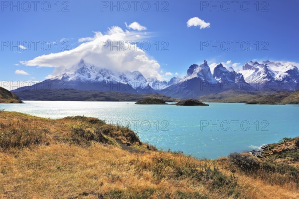 The strong wind drives turquoise waves on the lake, grandiose rocks Los Kuernos are covered with snow and ice. Magic beauty of the lake of Pehoe