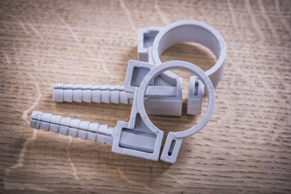 Polypropylene Fixators For Pipes On Wooden Board