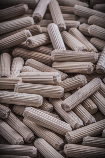 Collection of woodworking dowels on wooden board construction concept