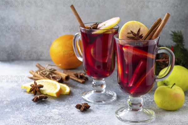 Christmas mulled wine, winter alcoholic drink. Two glass of mulled wine (gluhwein) and its ingredients on a stone background. Copy space