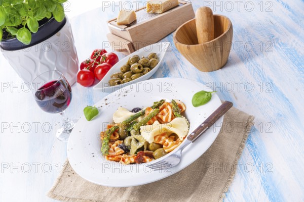 Colourful farfalle with green asparagus olives and parma ham