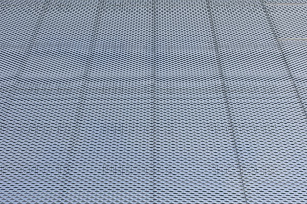 Closeup of metal mesh on concrete wall background texture