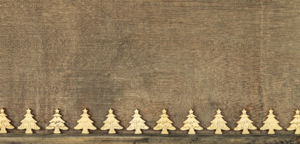 Christmas decoration wooden background with row of small wooden fir trees
