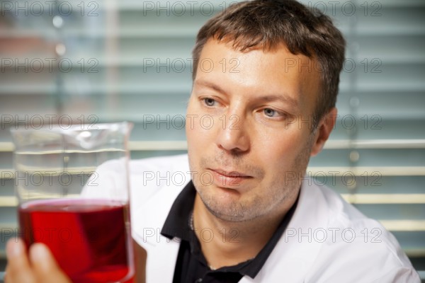 A man with red and yellow liquid in a laboratory