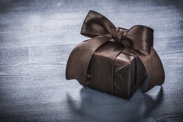 Giftbox shining paper on vintage wooden board holiday concept