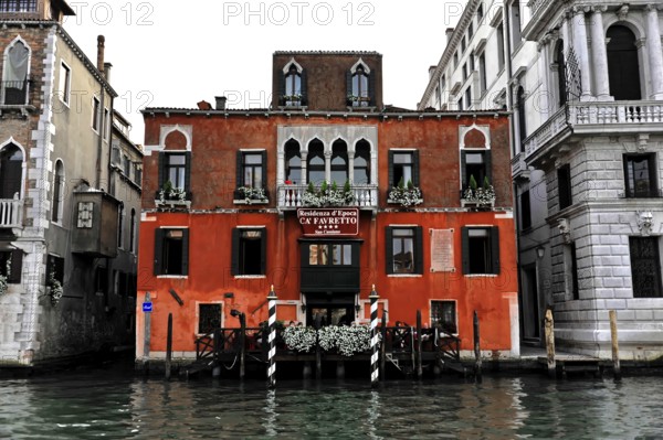Venice, Veneto, Italy, Europe, Red building with white window frames on a canal in Venice