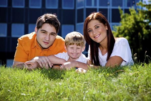 Young family on the meadow at sunny day