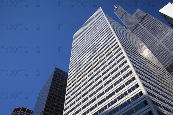 Looking up at business building in downtown, Chicago, USA. A view up through tall skyscrapers to a patch of blue sky