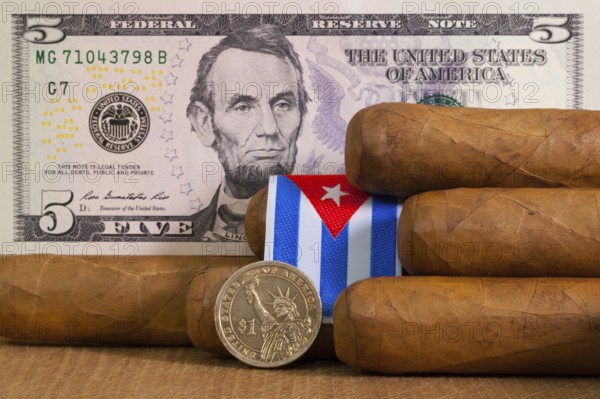 Luxury Cuban cigars with US dollar banknote and coin on the wooden table