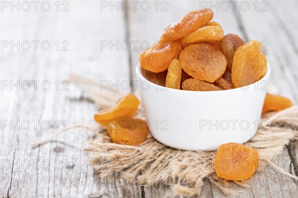 Small portion of dried Apricots (on wooden background)