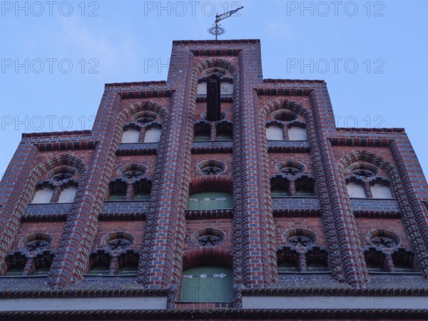 Close-up of a historic brick façade with window decorations and blue window, lüneburg, germany