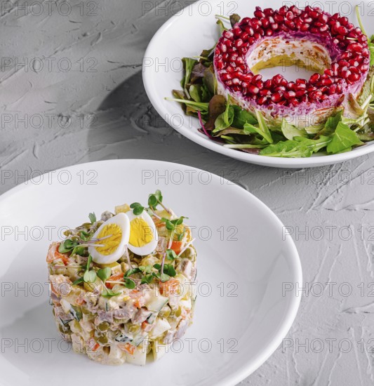 Food, Vibrant salad ring with pomegranate and traditional olivier salad on a festive table setting