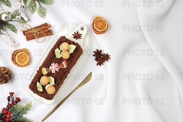 Homemade winter dessert, stollen or strudel with sweet cream filling, nuts, cinnamon and poppy seeds. Concept for holiday bakery, seasonal treats and cafe advertising, selective focus