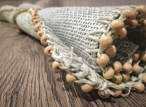 Small roller wicker mat on vintage table. Furnishing accessory for home. Close-up