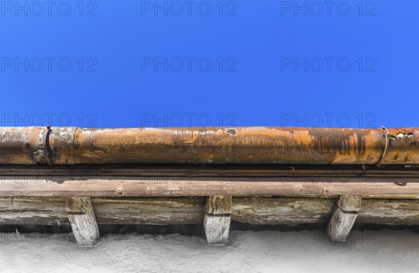 A broken gutter on the roof of a house