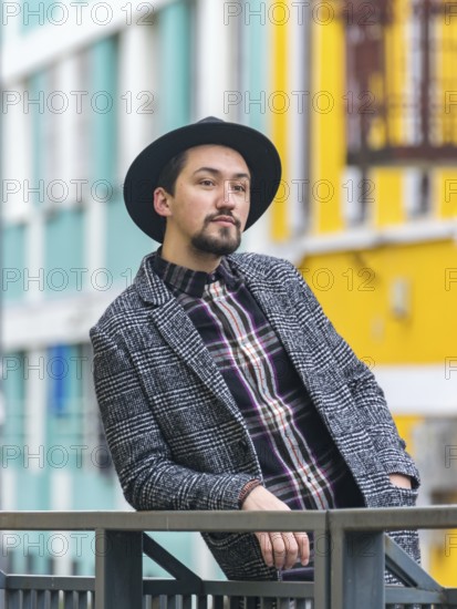 Portrait of a stylish handsome young man with a coat outdoors. A man wearing a coat and a shirt looking away and wondering