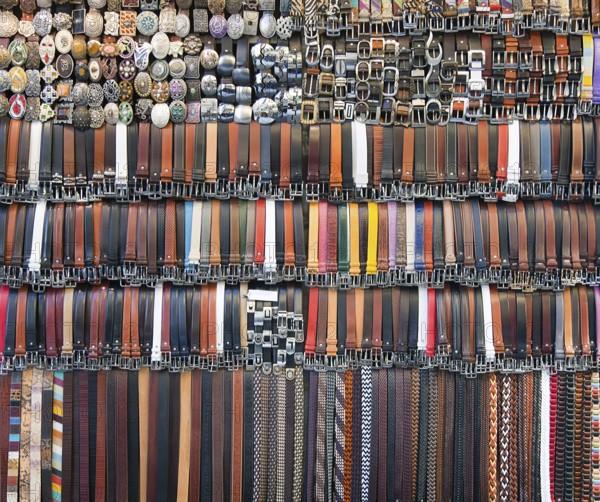 Many colored leather belts on a market
