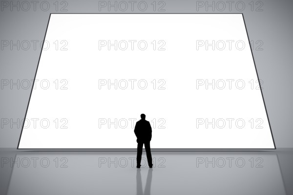 A man in front of a big white empty screen