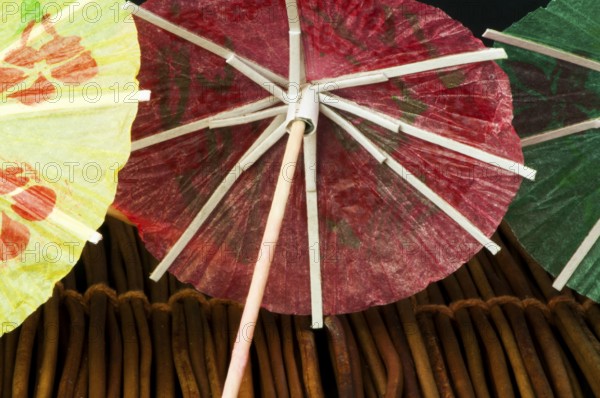 Colorful cocktail umbrellas on wooden base. Close up