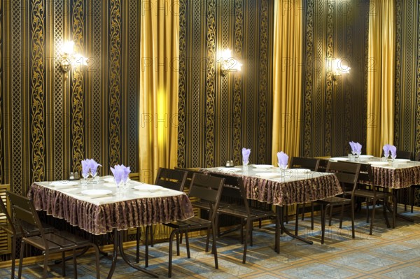 Served tables in a cafe, black and golden hues