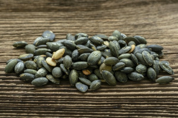 Pumpkin seeds seasoned using sea salt. Pumpkin seeds over wooden table