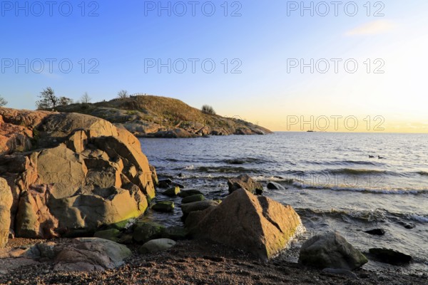 Waterfront view to Gulf of Finland near sunset time in October with seaside rocks, blue sea and blue sky. Suomenlinna, Finland