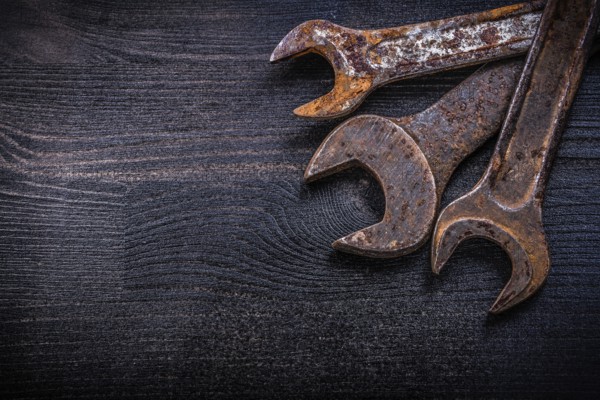 Vintage grunge open-end wrenches on wood board construction concept