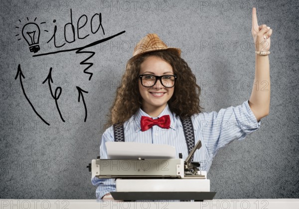 Young pretty woman writer with typing machine