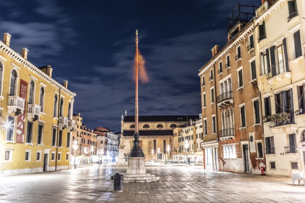 Venetian flag waving in the wind, illuminated facades, Campo Santo Stefano, night shot, Venice, Italy