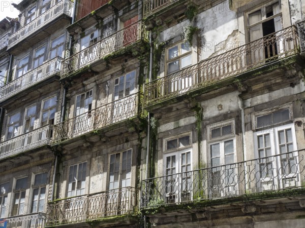 Weathered facades of old buildings with balconies and many windows, porto, portugal