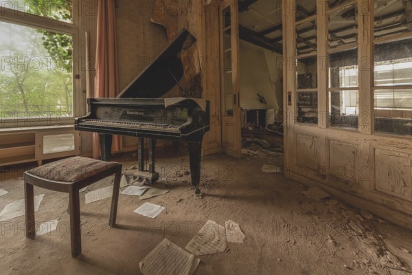 Abandoned room with a piano, sheets of paper on the floor and old walls, lost place, urologist's villa Dr Anna L., Bad Wildungen, Hesse, Germany