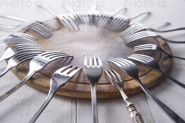 Sets of forks different shapes arranged on chopping round