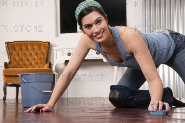 A woman tries to make fun out of cleaning the floor by hand