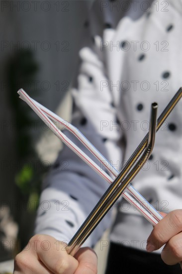 Woman holding Reusable Metal and plastic drinking Straws. Female Hand on reusable collapsible drinking straw. Eco lifestyle and zero waste concept. Plastic free. Stainless metal straws