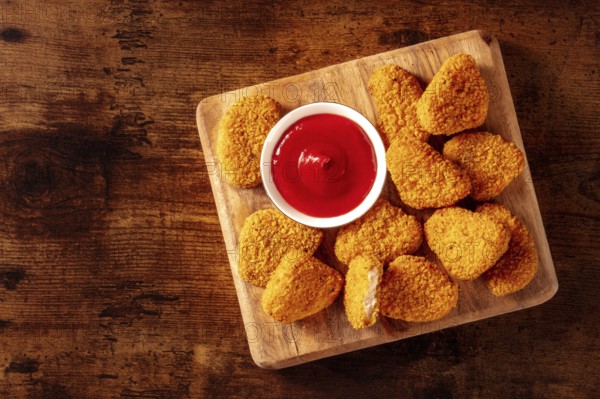 Chicken nuggets with ketchup on a rustic wooden table, shot from the top with a place for text. Crispy snack, Food photography, Food photography