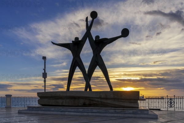 Taranto, Italy, 30 November, 2023: view of the Sailor Monument at the harbor entrance of Taranto at sunset