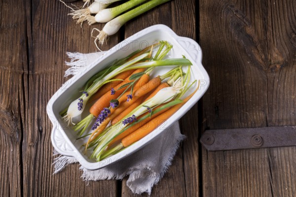 Young carrots and spring onions prepared for baking