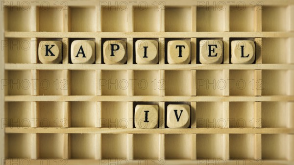 An image of a wooden game with the word chapter four in german language