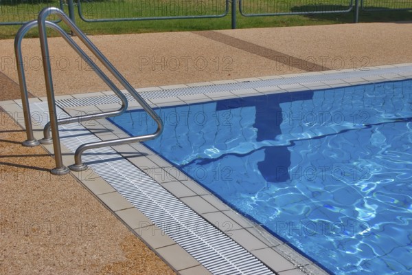 Pool with pure transparent water and hand-rail of descent