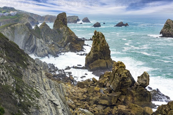 Noon on the beach of Playa di Arnia, Spain. Cantabria. Windy stormy day on the Atlantic coast. Rocky picturesque ocean coast