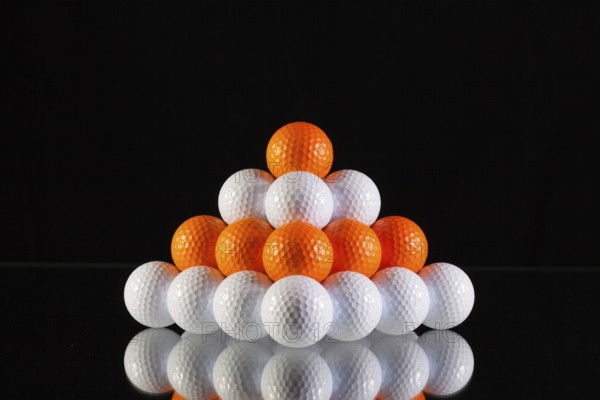 Pyramid of golf balls on a black background