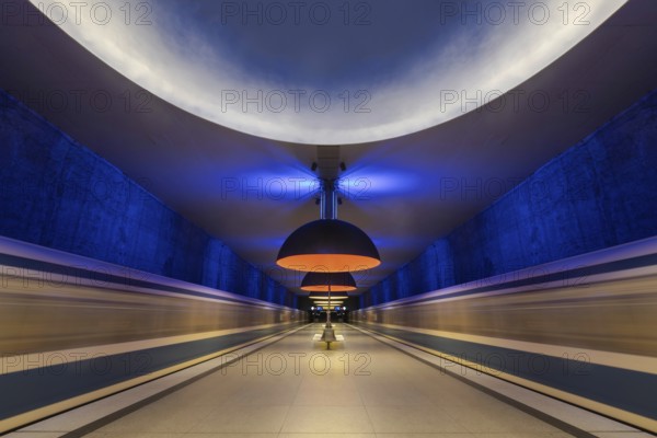 Futuristic underground railway tunnel with blue and yellow lighting, Munich, Bavaria, Germany