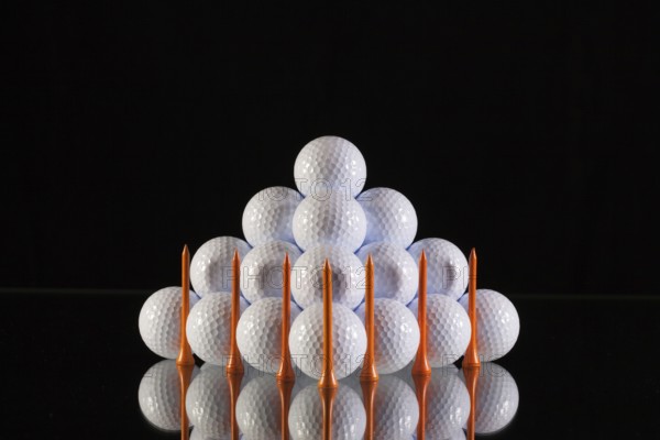 Pyramid of golf balls on a black background